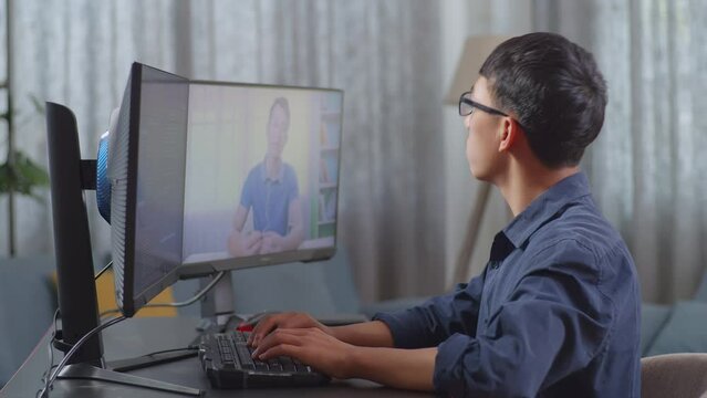Asian Boy Programmer Learning Online From Teacher On Desktop Computer While Creating Software Engineer Developing App, Program, Video Game At Home. Terminal With Coding Language 
