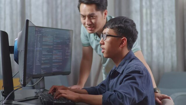 Asian Boy Students Studying Software Code From Male Teacher Or Father
