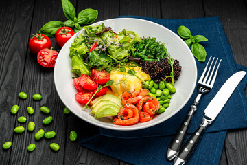 Healthy light breakfast with poached egg, salmon, avocado, tomato, lettuce and chia seeds