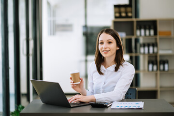 Asian businesswoman working in the office with working notepad, tablet and laptop documents .
