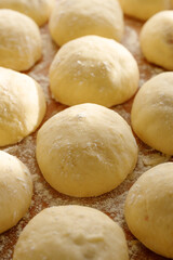 Fototapeta na wymiar Rising yeast buns, focus on the bun in the middle. Traditional yeast pastries