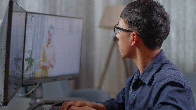 Close Up Of Asian Boy Programmer Learning Online From Teacher On Desktop Computer While Creating Software Engineer Developing App, Program, Video Game At Home. Terminal With Coding Language 
