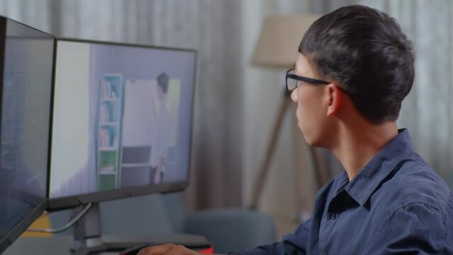 Close Up Of Asian Boy Programmer Learning Online From Teacher On Desktop Computer While Creating Software Engineer Developing App, Program, Video Game At Home. Terminal With Coding Language 
