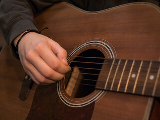 Obraz premium Practice playing the acoustic guitar. Hands playing guitar and picking chords
