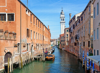 Fototapeta na wymiar Canal with boats in Venice and Greek orthodox church San Giorgio dei Greci in the background 