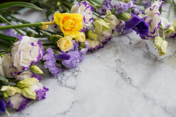 Frame made of various flowers on marble background. Flat lay, top view, copy space.Easter composition. romantic seasonal design element.Congratulatory template. Wedding invitation