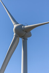 Detailed view of a wind turbine or wind mill, details at the main components: rotor blades, hub, nacelle and generator - obrazy, fototapety, plakaty