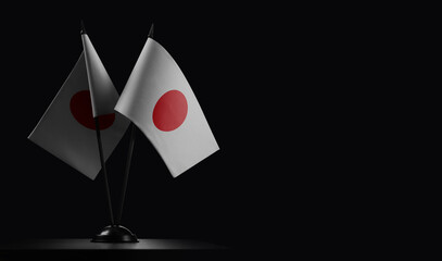 Small national flags of the Japan on a black background