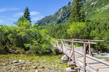 Wooden bridge crossing a stream at the hiking path to Popradske Pleso, Slovakia
