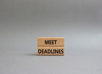 Meet Deadlines symbol. Concept word Meet Deadlines on wooden blocks. Beautiful grey background. Business and Meet Deadlines concept. Copy space