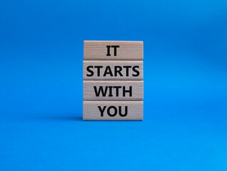 It starts with you symbol. Wooden blocks with words It starts with you. Beautiful blue background. Business and It starts with you concept. Copy space.
