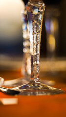 Macro de pieds de verre posés sur une table à la nappe orange, dans un restaurant