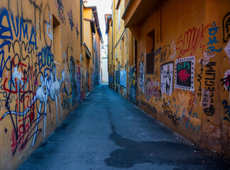 Alley with yellow walls and graffiti