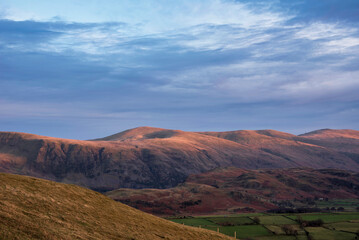 Wonderful vibrant sunset landscape image of view from Latrigg Fell towards Great Dodd and Stybarrow Dodd in Lake District
