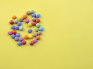 Obraz premium Colorful candies on yellow background