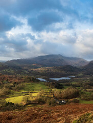 Fototapeta na wymiar Stunning Winter sunrise golden hour landscape view from Loughrigg Fell across the countryside towards Langdale Pikes in the Lake District