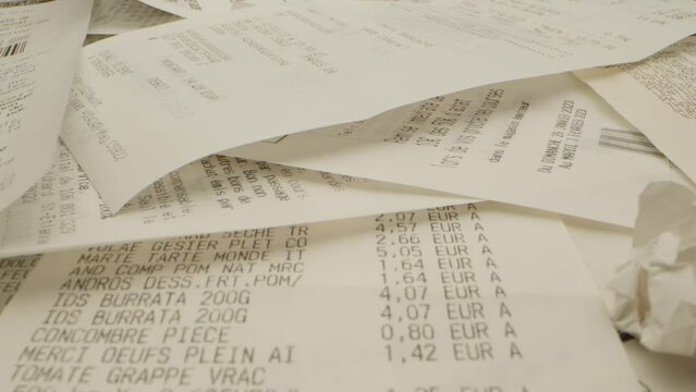 gros plan de plusieurs tickets de caisses &eacute;parpill&eacute;s avec un billet de banque de cinq euros et des pi&egrave;ces de monnaie