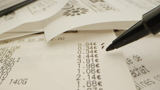 v&eacute;rification de l'inflation sur un ticket de caisse de supermarch&eacute; en euros avec un stylo feutre noir