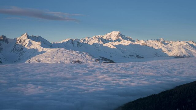 Time-lapse view of cloud inversion with Mont Blanc at distance during sunset. Viewed from La Plagne ski resort, day to night transition