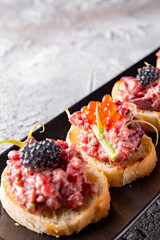 bruschetta with salmon and tuna fish tartare on plate