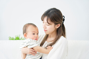 家で赤ちゃんを抱っこする母親