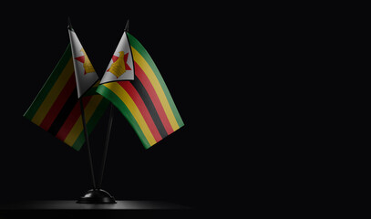 Small national flags of the Zimbabwe on a black background