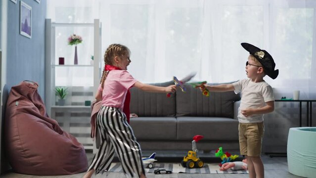 Preschooler and toddler play duel on swords in living room