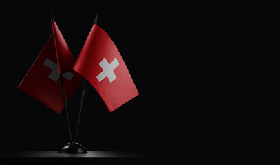 Small national flags of the Switzerland on a black background