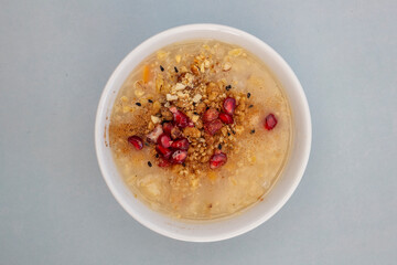 Traditional Turkish Dessert Aşure or Noah Pudding in glass bowl. Conceptual image of the Day of Ashura in the Islamic Calendar.