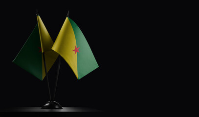 Small national flags of the French Guiana on a black background