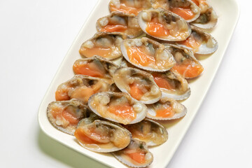 Fresh baby clams in box isolated on white dish. Ready to cook for delicious seafood menu.