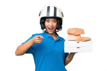 Young Argentinian deliver fast food over isolated background surprised and pointing front