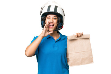 Young Argentinian woman taking a bag of takeaway food over isolated background shouting with mouth wide open