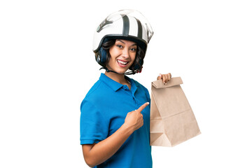 Young Argentinian woman taking a bag of takeaway food over isolated background and pointing it