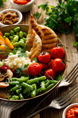 Healthy salad, buddha bowl with a set of  vegetables with the addition of grilled chicken breasts and millet groats, close up view