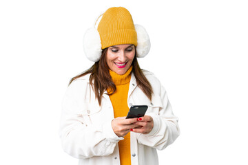 Middle age woman wearing winter muffs over isolated chroma key background sending a message with the mobile