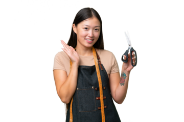Young Asian seamstress woman over isolated background saluting with hand with happy expression