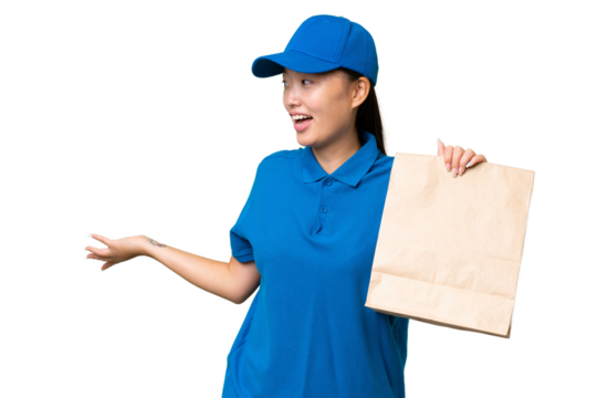 Young Asian woman taking a bag of takeaway food over isolated background with surprise expression while looking side