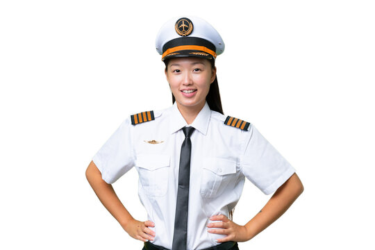 Airplane pilot Asian woman over isolated background posing with arms at hip and smiling - Powered by Adobe