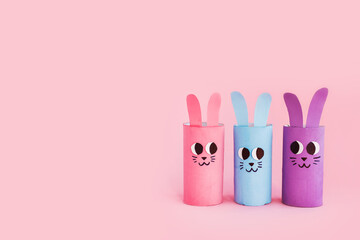 Holiday easy DIY craft idea for kids. Toilet paper roll tube toy's cute rabbit's on pink background. Creative Easter or Christmas decoration eco-friendly, reuse, recycle handmade minimal concept