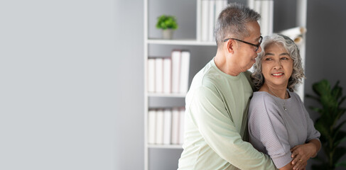 Happy senior adult  couple hugging, bonding their healthy relationship together in the living room.