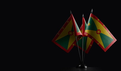 Small national flags of the Grenada on a black background