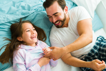Cheerful dad laughing and playing with her daughter