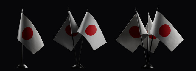 Small national flags of the Japan on a black background