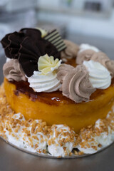 Tarta de yema tostada con trufa y nata decorada con chocolate negro y chocolate blanco