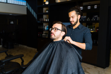 Male hairstylist doing a new haircut to a client