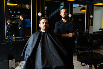Fototapeta na wymiar Male customer and barber at an elegant barber shop or salon