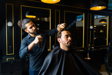 Fototapeta na wymiar Handsome man client getting a haircut at the salon
