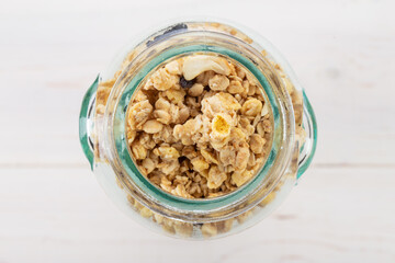 Glass jar of muesli and granola on wooden background. Healthy breakfast. Top view.