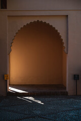 Soft sunlight enters through the arched doorway of Alcazaba palace in Malaga, Spain